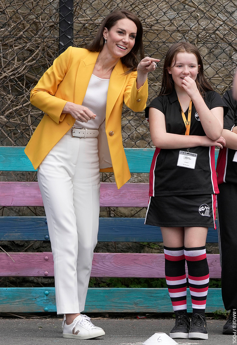 Kate Middleton wearing her white cigarette trousers with sneakers and a bright blazer