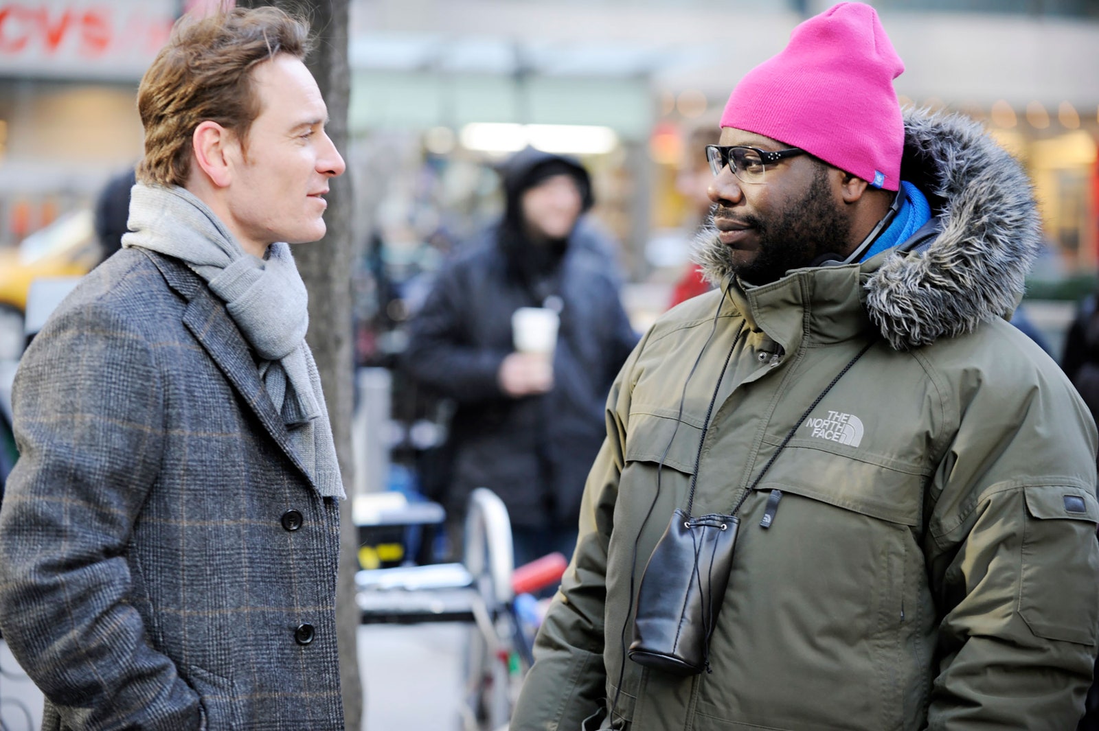 Image may contain Steve McQueen Michael Fassbender Christian Jones Clothing Coat Jacket Cap Hat Accessories and Bag