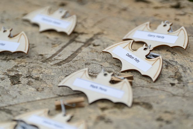 Small wood bats are labeled with the names of deceased homeless people and are called out individually at a memorial service at Auditorium Shores on Sunday, Nov. 17, 2024 in Austin. Advocates and members of the homeless community gathered to honor the more than 200 homeless people that died between September of 2023 and November of 2024.