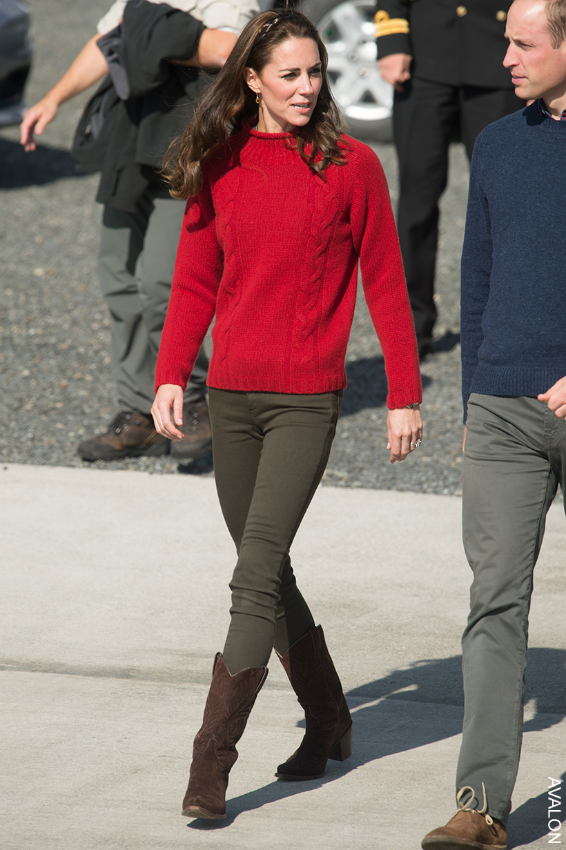 Kate Middleton pairs khaki jeans with brown cowboy boots and a red chunky sweater, finishing the look with a headband